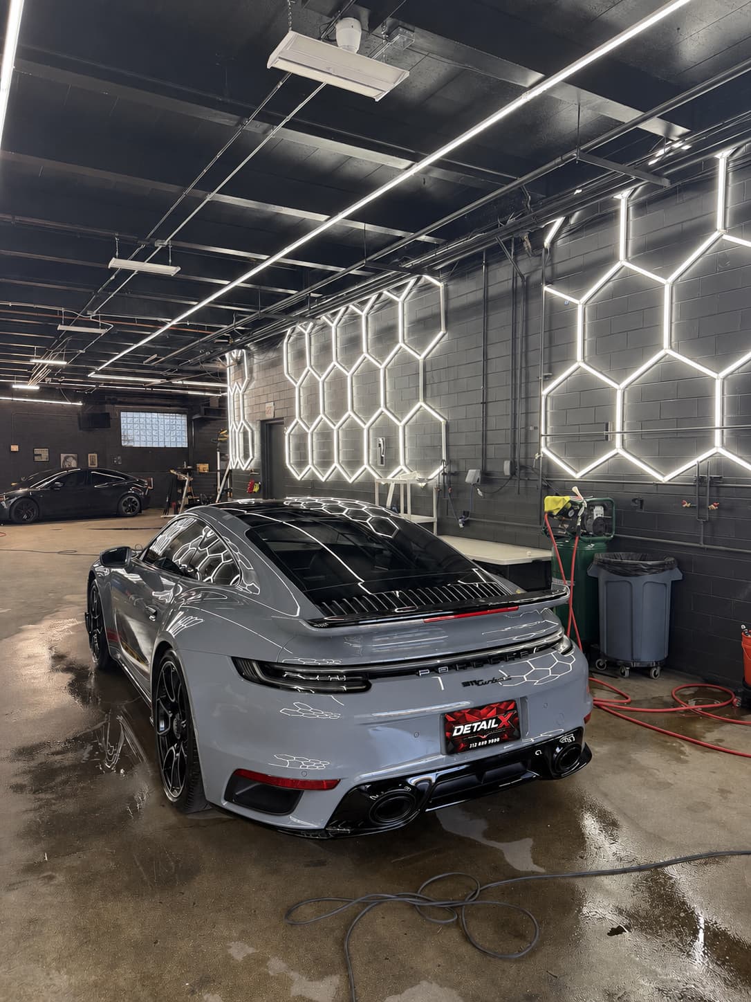 Rear view of a grey Porsche 911 in the DETAILX detail bay after service.